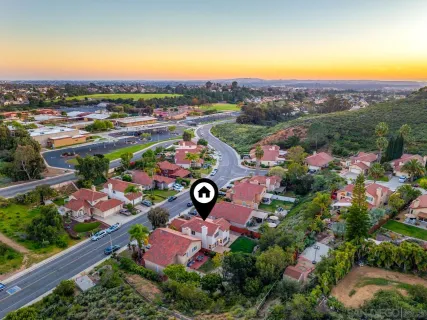 an aerial view of residential houses with outdoor space and parking