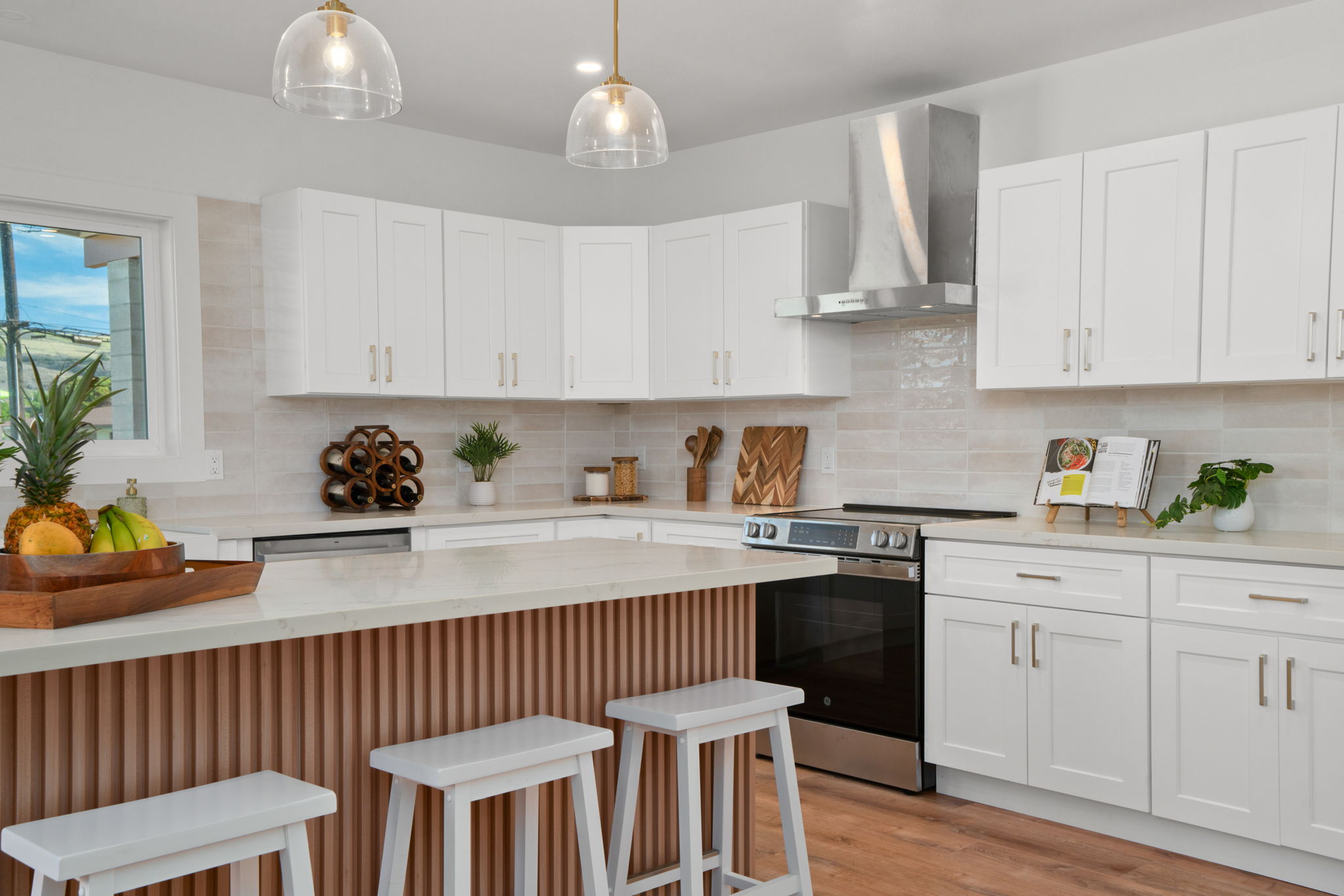 a kitchen with stainless steel appliances a sink a stove a dining table and chairs