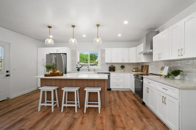 a kitchen with wooden floors and white cabinets