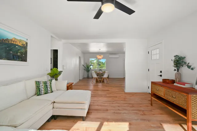 a dining room with furniture a chandelier and wooden floor