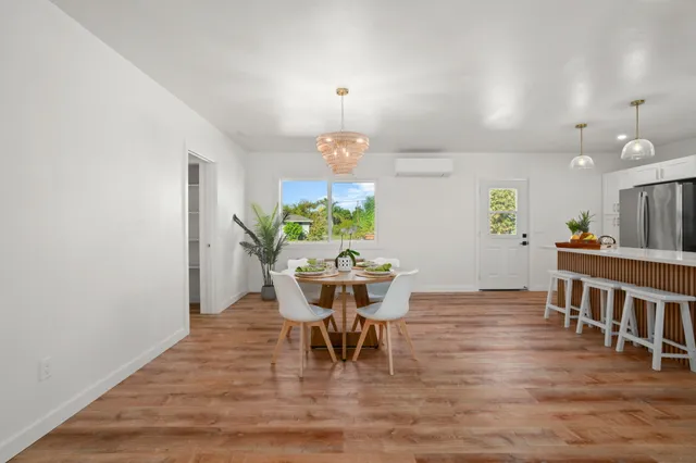 a dining room with furniture a chandelier and wooden floor