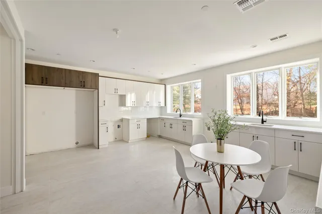 a kitchen with stainless steel appliances a dining table and chairs