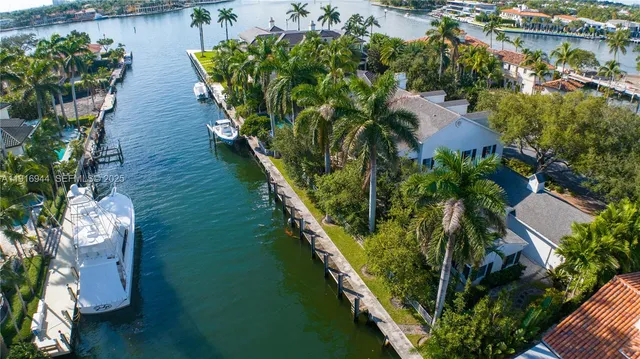 an aerial view of residential houses with outdoor space and trees