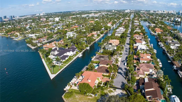 an aerial view of residential houses with outdoor space and trees