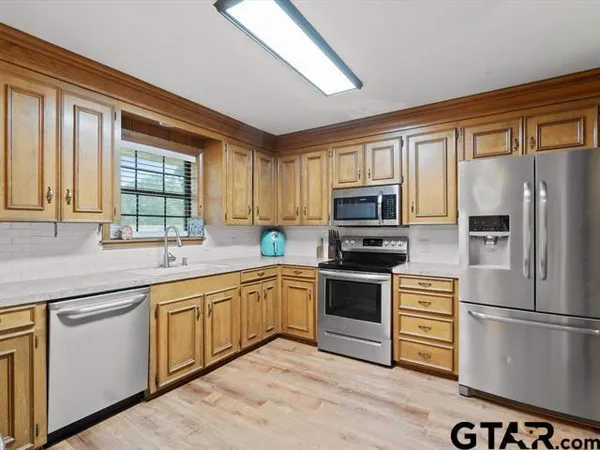 a kitchen with stainless steel appliances granite countertop a refrigerator microwave and stove top oven