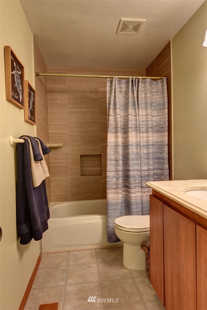 2206 168th Street Southeast Bothell, WA 98012 - Photo 14 of 21 a bathroom with a toilet and a shower curtain