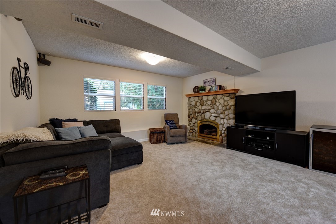 2206 168th Street Southeast Bothell, WA 98012 - Photo 17 of 21 a living room with furniture a flat screen tv and a fireplace