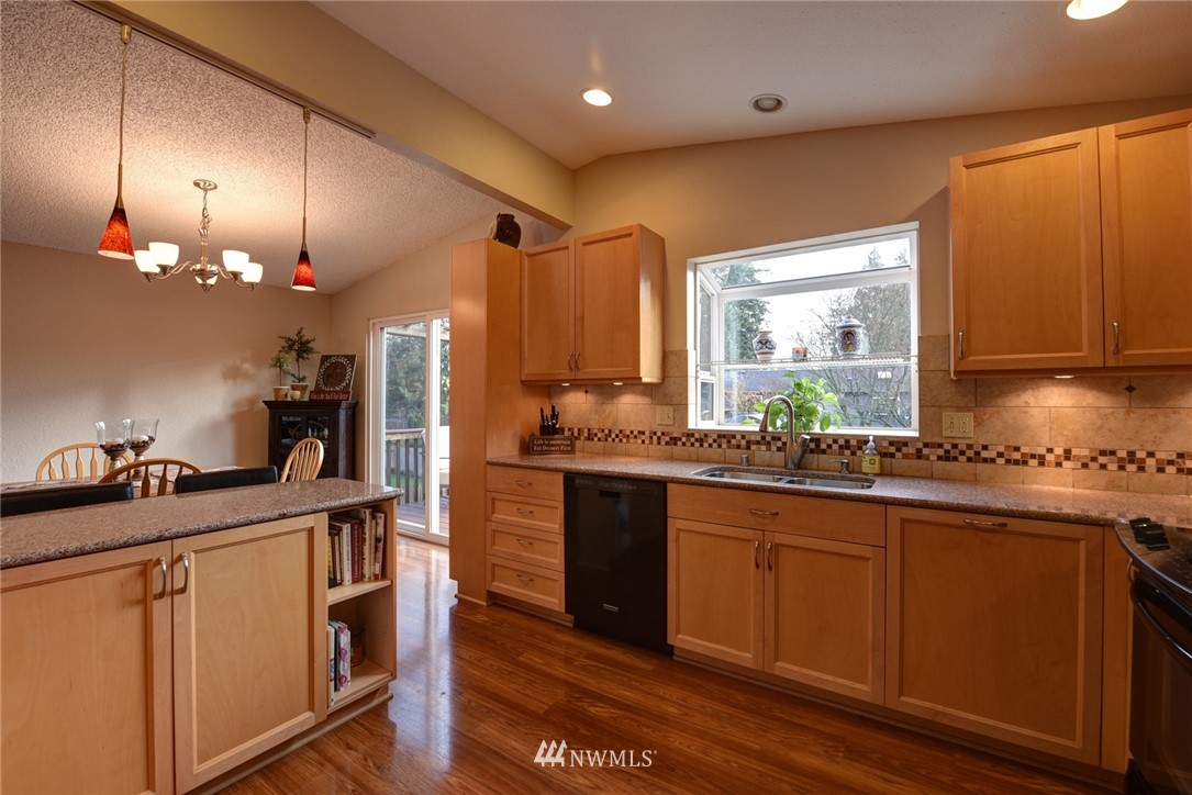 2206 168th Street Southeast Bothell, WA 98012 - Photo 3 of 21 a kitchen with kitchen island granite countertop a sink cabinets and stainless steel appliances