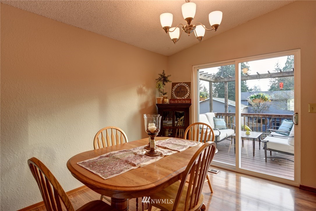 2206 168th Street Southeast Bothell, WA 98012 - Photo 6 of 21 a view of a dining room with furniture a chandelier and wooden floor
