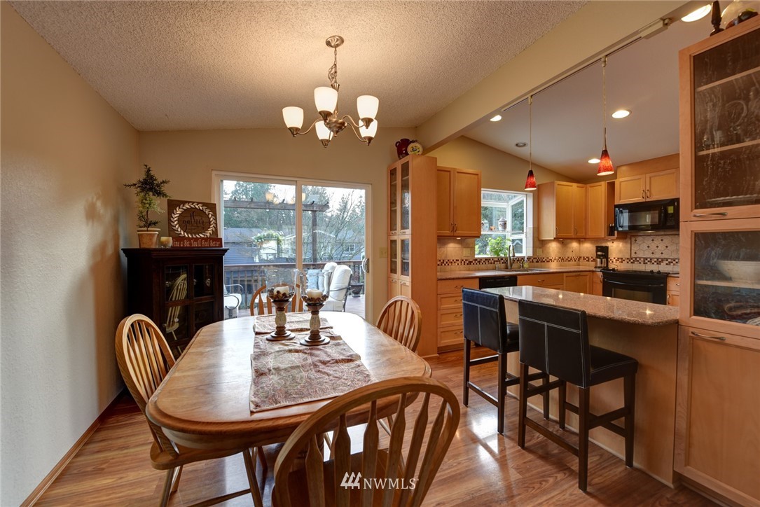 2206 168th Street Southeast Bothell, WA 98012 - Photo 7 of 21 a view of a dining room with furniture wooden floor and chandelier