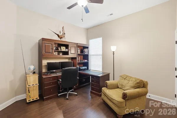a kitchen with stainless steel appliances kitchen island granite countertop a refrigerator a stove a sink a dining table and chairs with wooden floor