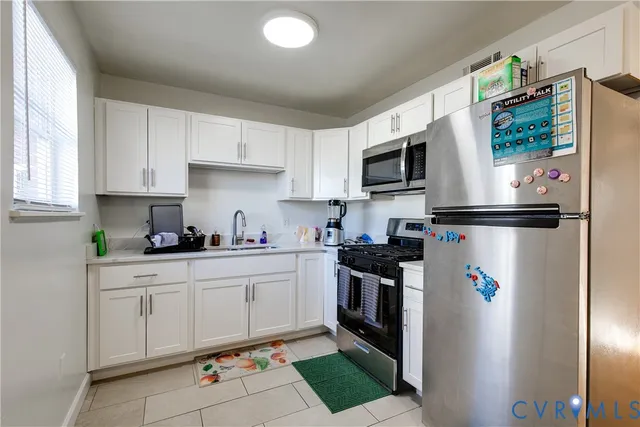 a kitchen with stainless steel appliances granite countertop a refrigerator sink and stove