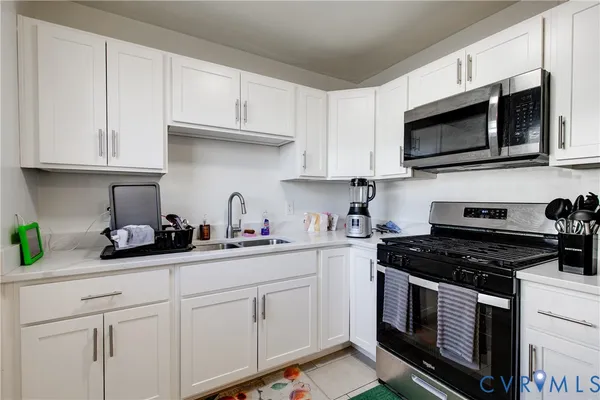 a kitchen with white cabinets and black appliances