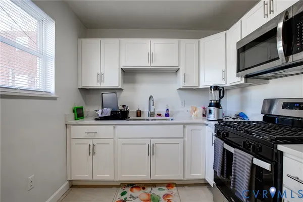 a kitchen with white cabinets and appliances