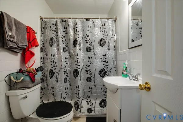 a bathroom with a toilet and a shower curtain