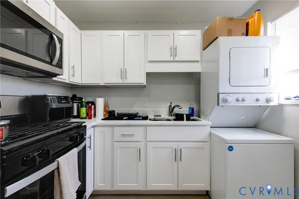 a kitchen with white cabinets and appliances