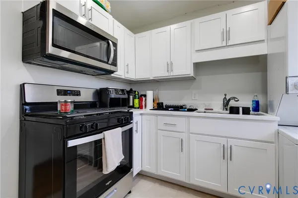 a kitchen with white cabinets and stainless steel appliances