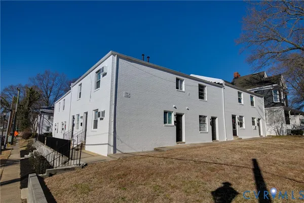 a view of house with backyard and trees in the background
