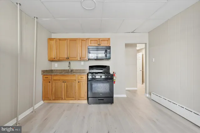 a kitchen with granite countertop a stove a sink and a microwave
