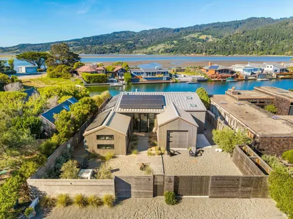 an aerial view of a house with a garden and lake view