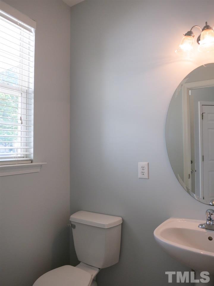 8516 Barryknoll Court Raleigh, NC 27613 - Photo 12 of 25 The Half Bath offers a neutral tile floor & pedestal sink.