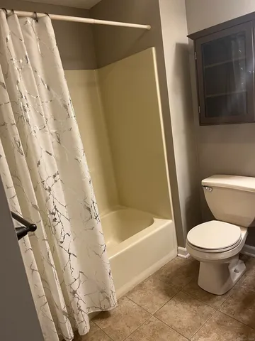 a bathroom with a toilet and a shower