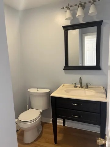a bathroom with a toilet sink vanity and mirror