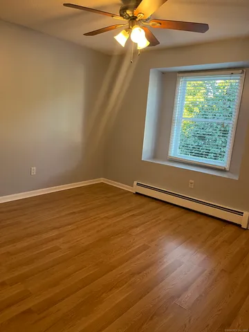 a view of a room with wooden floor and fan