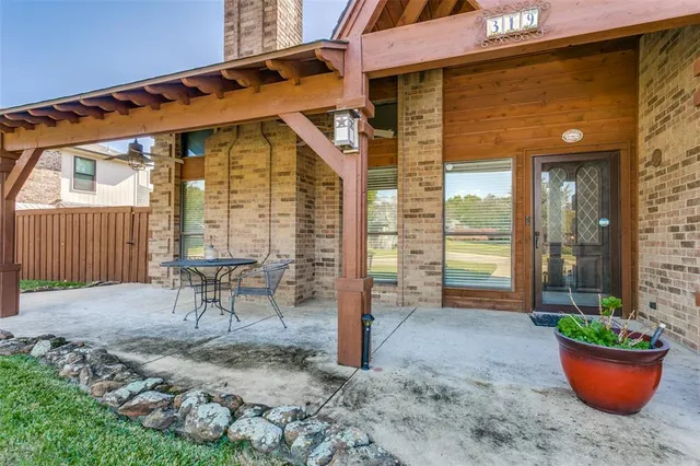a view of a chair and table in backyard of the house