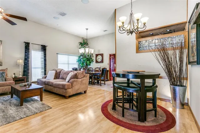 a living room with furniture a dining table and a chandelier
