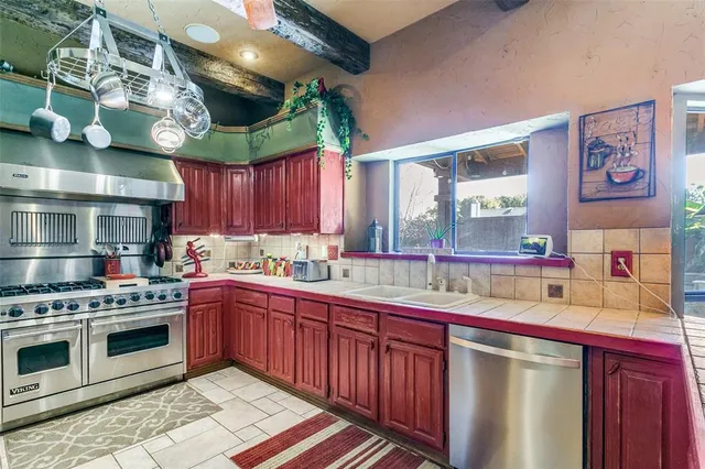 a kitchen with stainless steel appliances granite countertop a stove a sink and a microwave