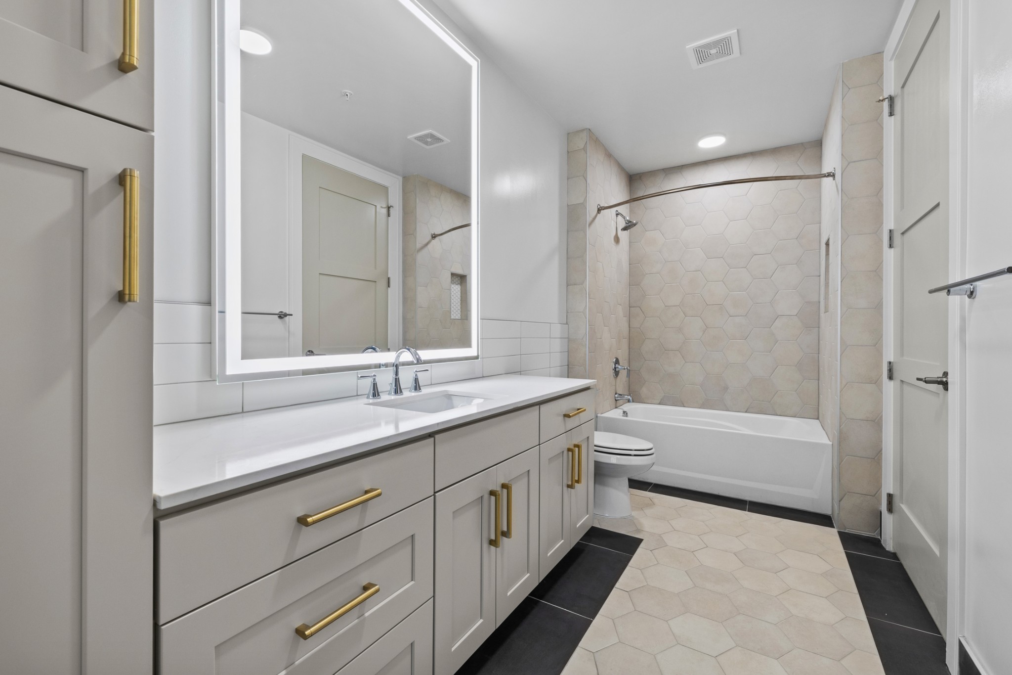 930 Commerce Street, Unit 508 Nashville, TN 37203 - Photo 20 of 65 a bathroom with a double vanity sink toilet mirror and bathtub