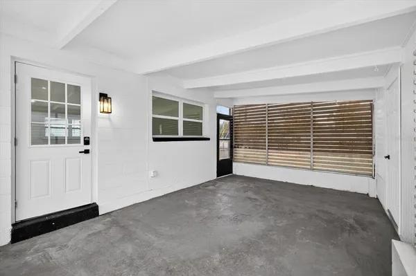 an empty room with wooden floor a ceiling fan and windows
