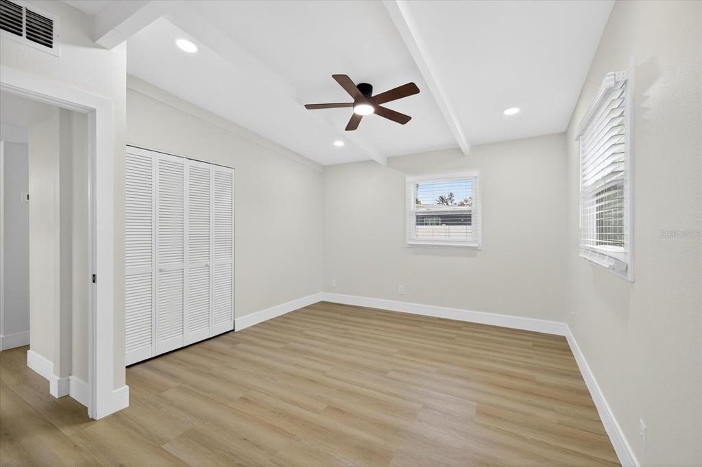 5901 South Coolidge Avenue Tampa, FL 33616 - Photo 31 of 47 an empty room with wooden floor a ceiling fan and windows