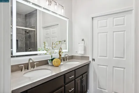 a en suite bathroom with a granite countertop sink and a mirror