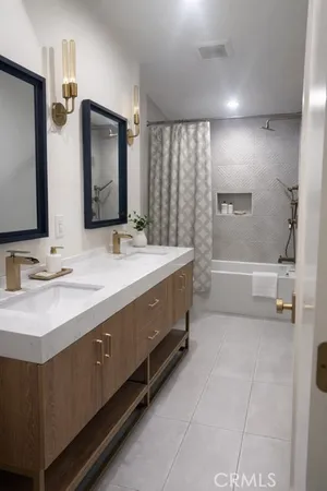 a bathroom with a double vanity sink a mirror and a bathtub