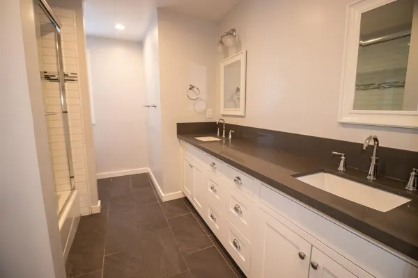 a bathroom with double vanity and a bathtub