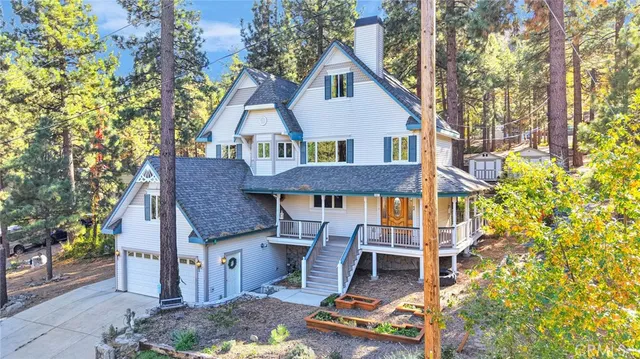 a view of a house with wooden fence and large trees