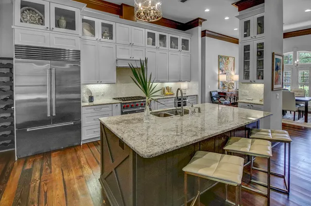 a kitchen with kitchen island a wooden floor and a refrigerator