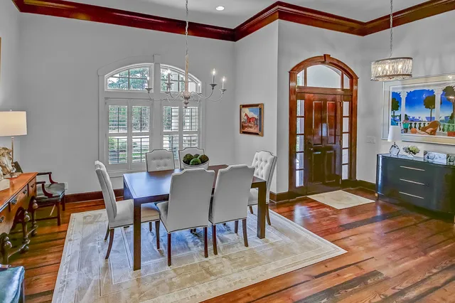 a view of a dining room with furniture a chandelier and wooden floor