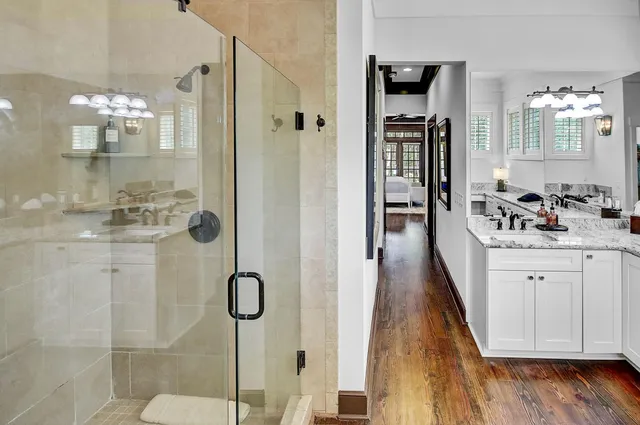 a bathroom with a granite countertop shower a sink and a mirror