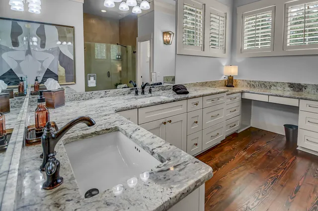 a spacious bathroom with a granite countertop sink and a mirror