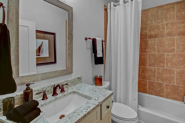 a bathroom with a granite countertop sink toilet and shower
