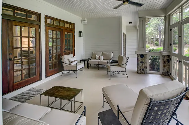 a living room with furniture and floor to ceiling windows