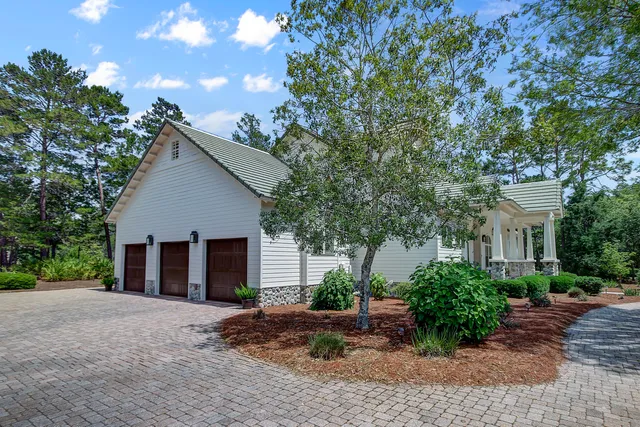 a view of a house with a yard and large tree