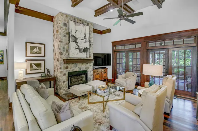 a living room with furniture a fireplace and a floor to ceiling window