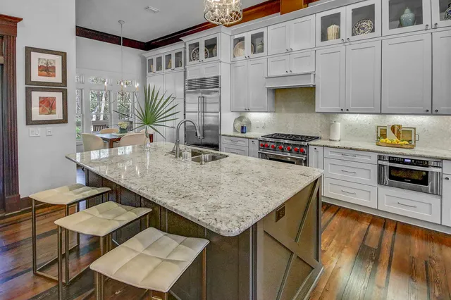 a kitchen with granite countertop a stove a sink a counter space and cabinets