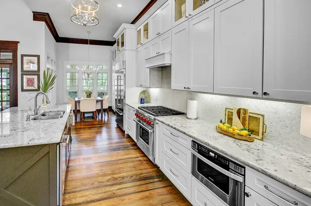 a kitchen with stainless steel appliances granite countertop a lot of counter space and wooden floors