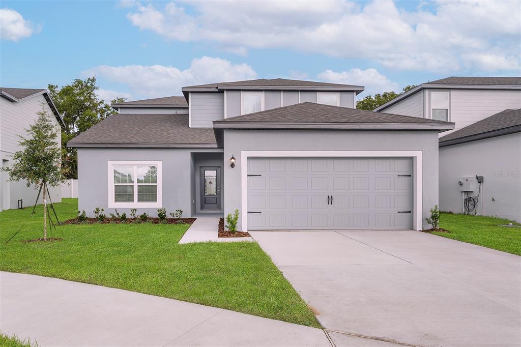 a front view of a house with a yard and garage