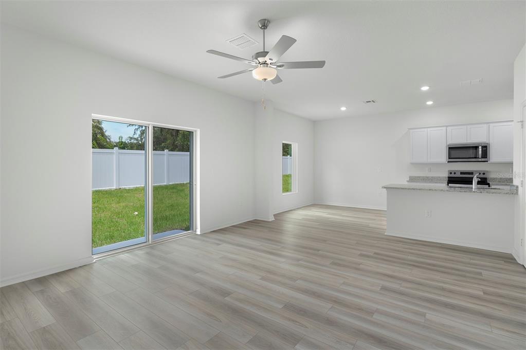 13348 Tula Loop Astatula, FL 34705 - Photo 5 of 22 a view of an empty room with a window and kitchen view